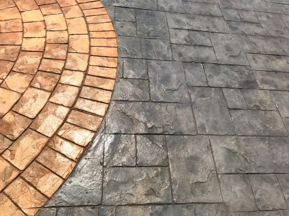 Two-tone stamped concrete patio featuring brick and natural stone patterns